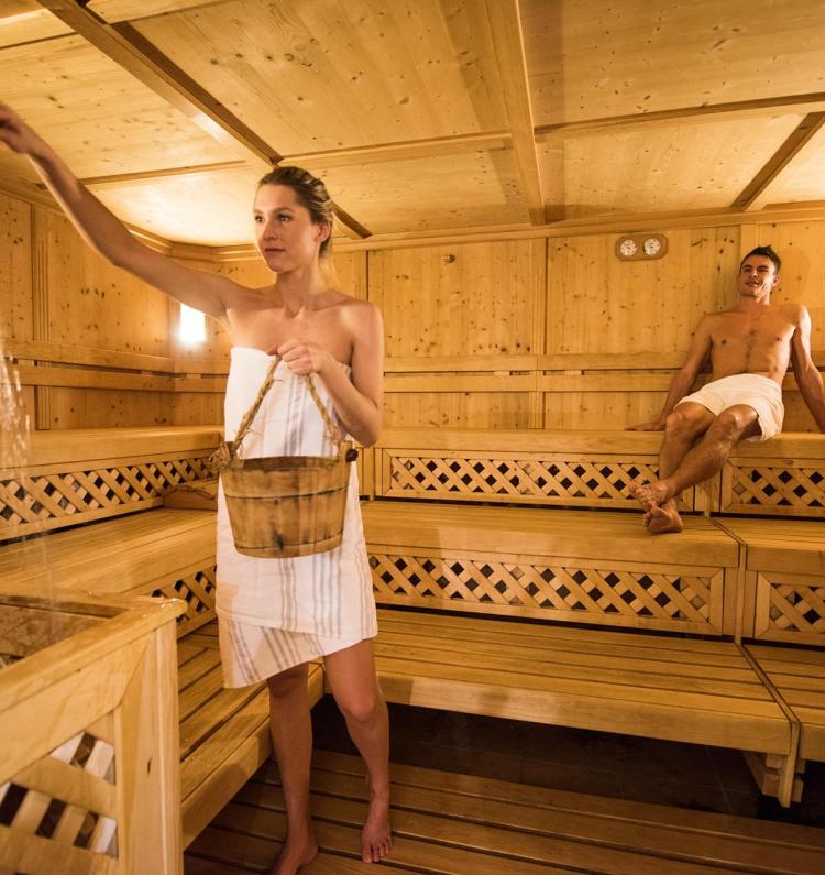 Sprinkling water on the hot stones of the sauna