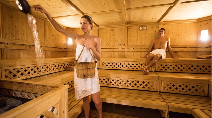 Sprinkling water on the hot stones of the sauna